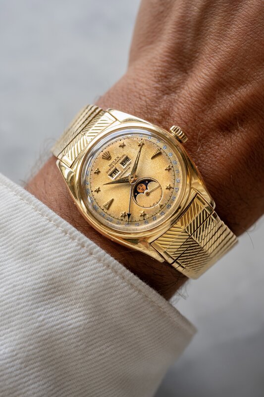 Wrist shot of the gold Rolex ref. 6062 Stelline on Jimmy's wrist with a white shirt cuff, day aperture reading FRI and month APR