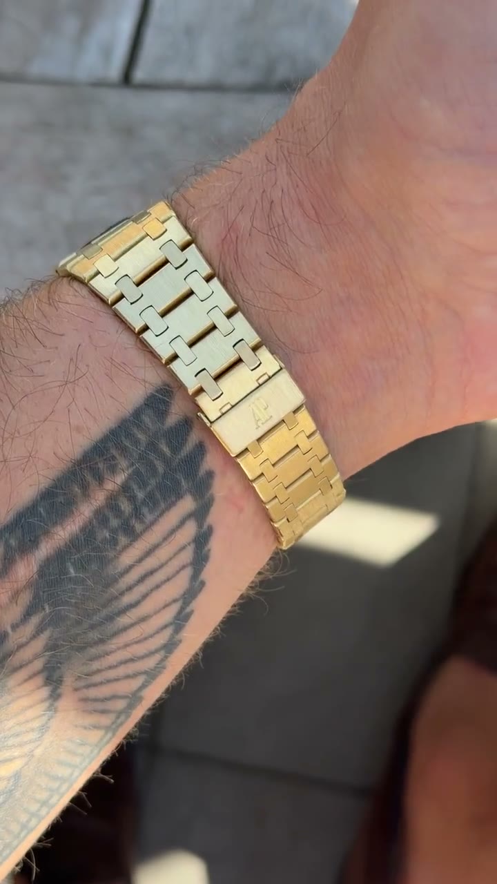 A gold Audemars Piguet Royal Oak on the wrist in sunlight, integrated gold bracelet catching the light