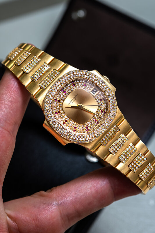Same Patek Philippe Nautilus held in hand — full diamond and gold bracelet detail