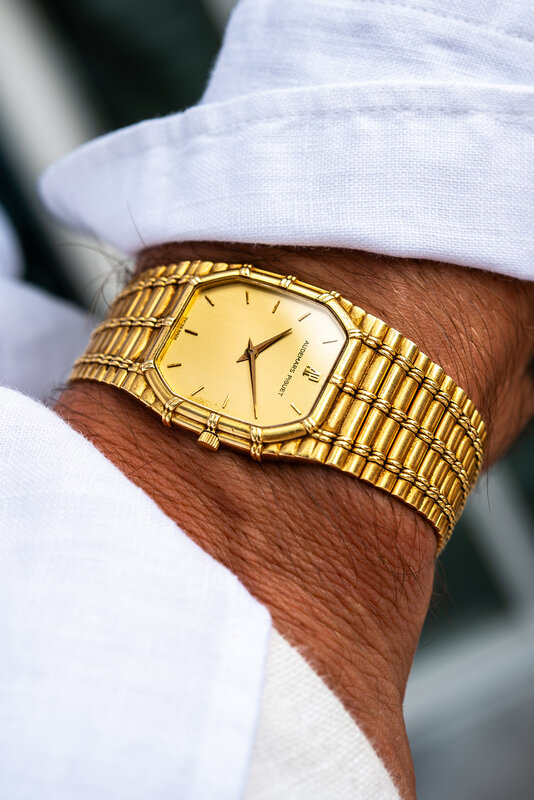 Vintage gold rectangular dress watch on wrist with a linen sleeve — champagne dial, Roman numerals