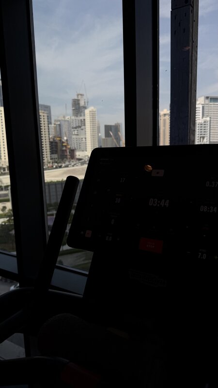 Hotel gym treadmill with Dubai Business Bay skyline through the windows
