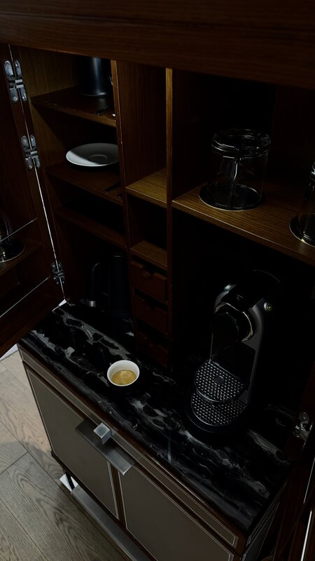 Hotel suite minibar with Nespresso machine and espresso cup