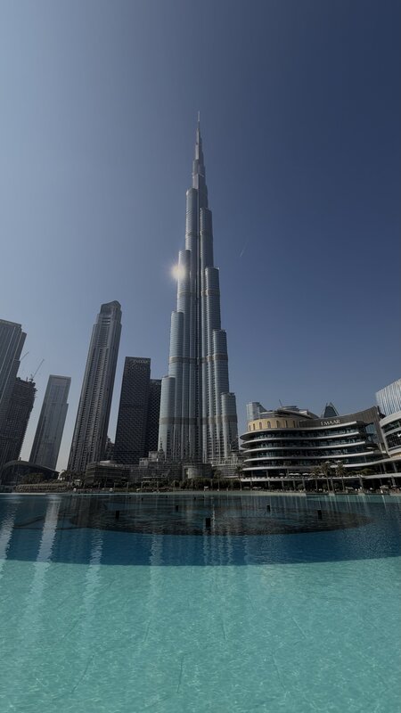 Burj Khalifa reflecting in the Dubai Fountain pool on a clear day