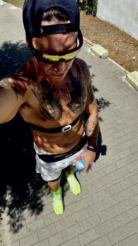 Jimmy in running kit holding a water bottle, cap backwards and sunglasses on, a heart-rate strap across his chest