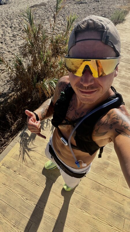 Jimmy after a run on the beach boardwalk, cap and mirrored sunglasses on, the hydration hose across his chest