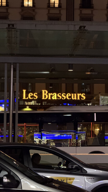 Les Brasseurs restaurant sign illuminated at night in Geneva