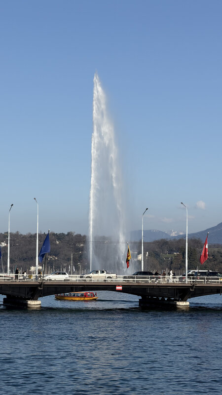 Jet d'Eau water jet on Lake Léman, seen from across the Pont du Mont-Blanc on a clear blue-sky day