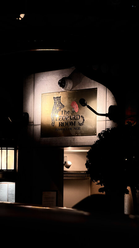 Leopard Room hotel bar entrance sign lit up at night — Hotel d'Angleterre Geneva