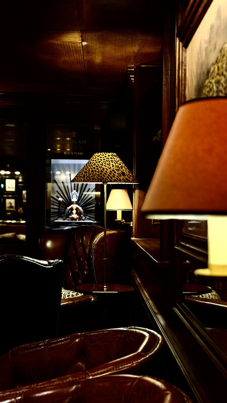 Inside the Leopard Room — leather chesterfields, leopard-print lamp shades, dark wood