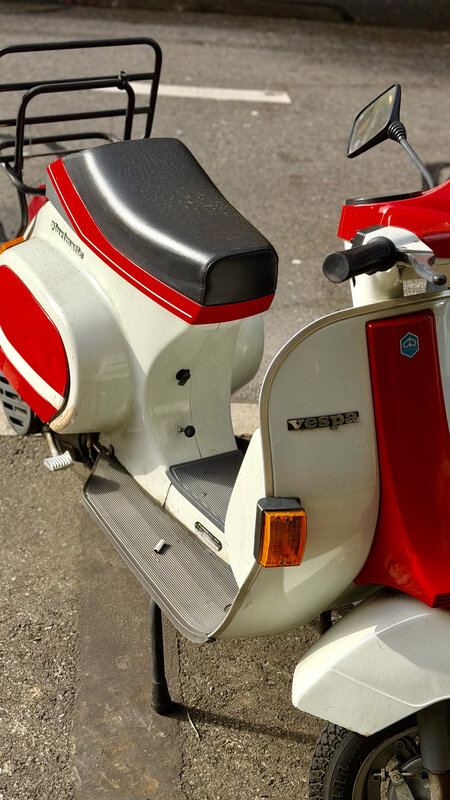 Vintage white and red Vespa scooter parked on a Geneva street