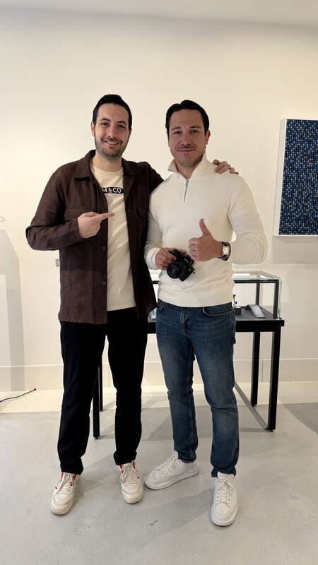 Jimmy posing with Arthur Touchot, founder of Marteau & Co, inside the Mad Gallery preview — Arthur in a brown jacket, Jimmy holding a camera