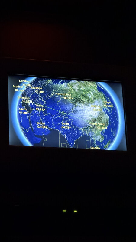 Inflight seat-back screen showing the flight map across Asia on the way to Hong Kong