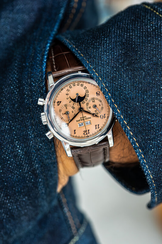 Platinum Patek Philippe 3970EP-038 perpetual calendar chronograph with a salmon dial, applied Breguet numerals and moon phase, on a brown alligator strap against a denim jacket