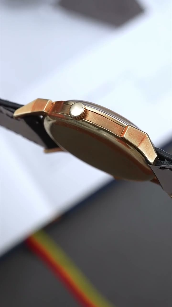 Video: the yellow-gold Patek Philippe 2523 lying on the pages of an open book, then picked up and worn on the wrist