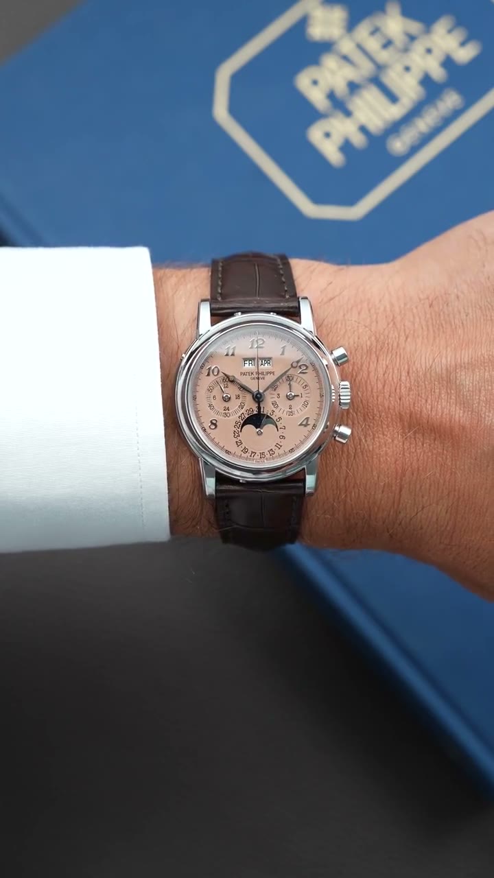 Video: the platinum Patek Philippe 3970EP-038 on the wrist beside a white shirt cuff, salmon dial and moonphase turning into the light, the brand's blue box behind
