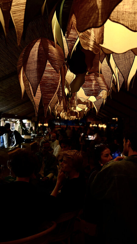 Kabana interior — guests mingling under sculptural pendant lights