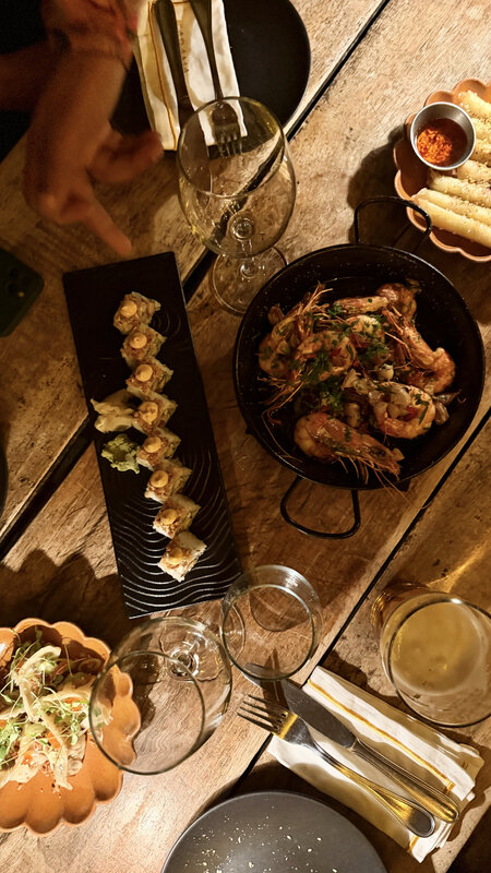 Food spread at Kabana — grilled prawns, dumplings, dipping sauces, wine