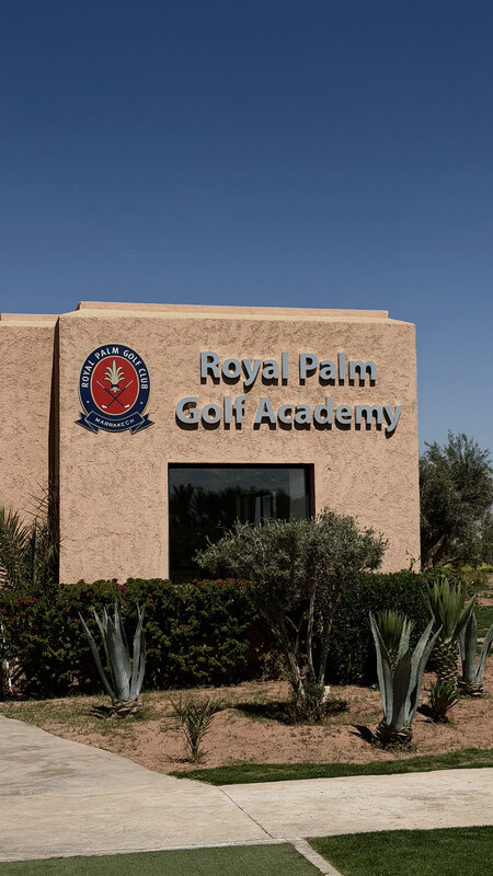 Royal Palm Golf Academy building — terracotta walls, blue sky