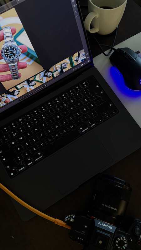 Laptop on a Watch Trading Co workspace — editing software open with watch photo on screen