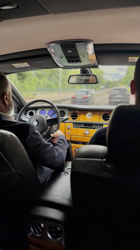 View from the back seat of the chauffeur-driven Franck Muller Rolls-Royce, burl-wood dashboard and the driver at the wheel on the motorway into Geneva